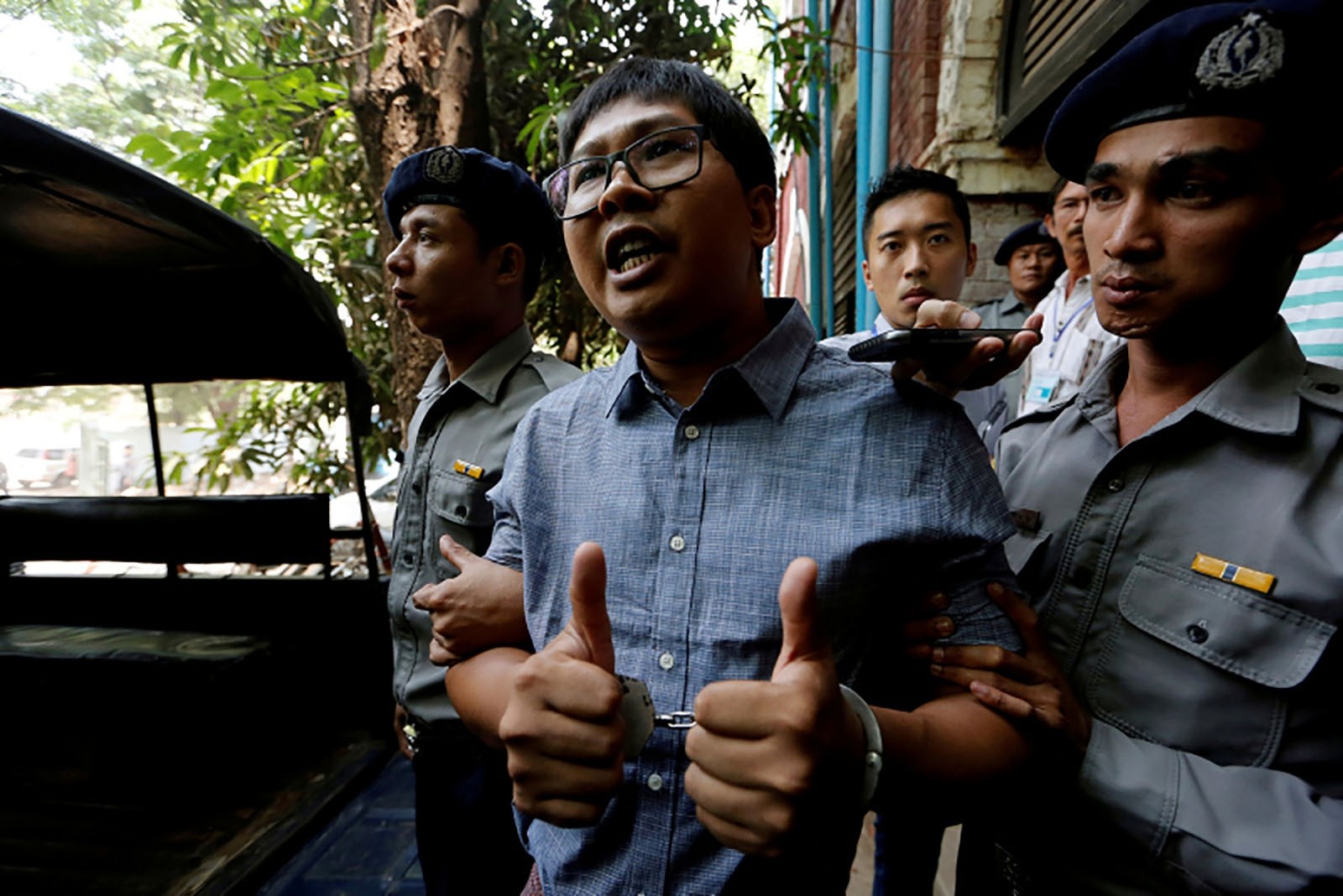 Detained Reuters journalist Wa Lone is escorted by police after a court hearing in Yangon, Myanmar April 4, 2018. 