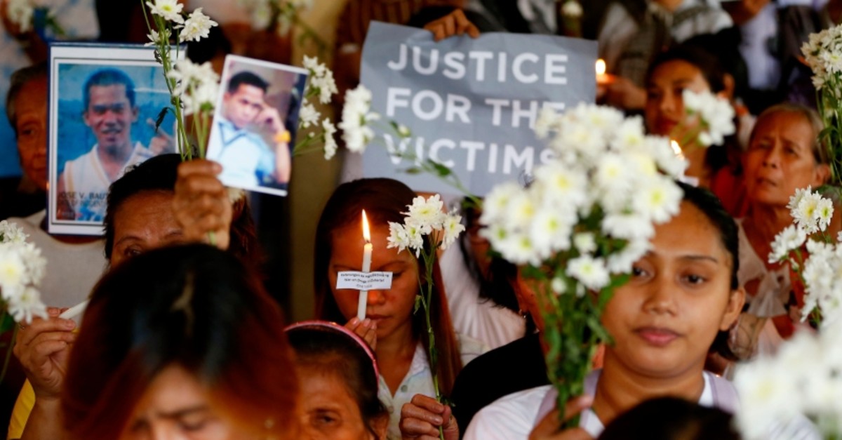 Relatives of victims in President Rodrigo Duterte's war on drugs hold lit candles and display portraits of their loved ones as they gather at a Roman Catholic church in suburban Quezon city northeast of Manila, Philippines, March 15, 2019. (AP Photo)