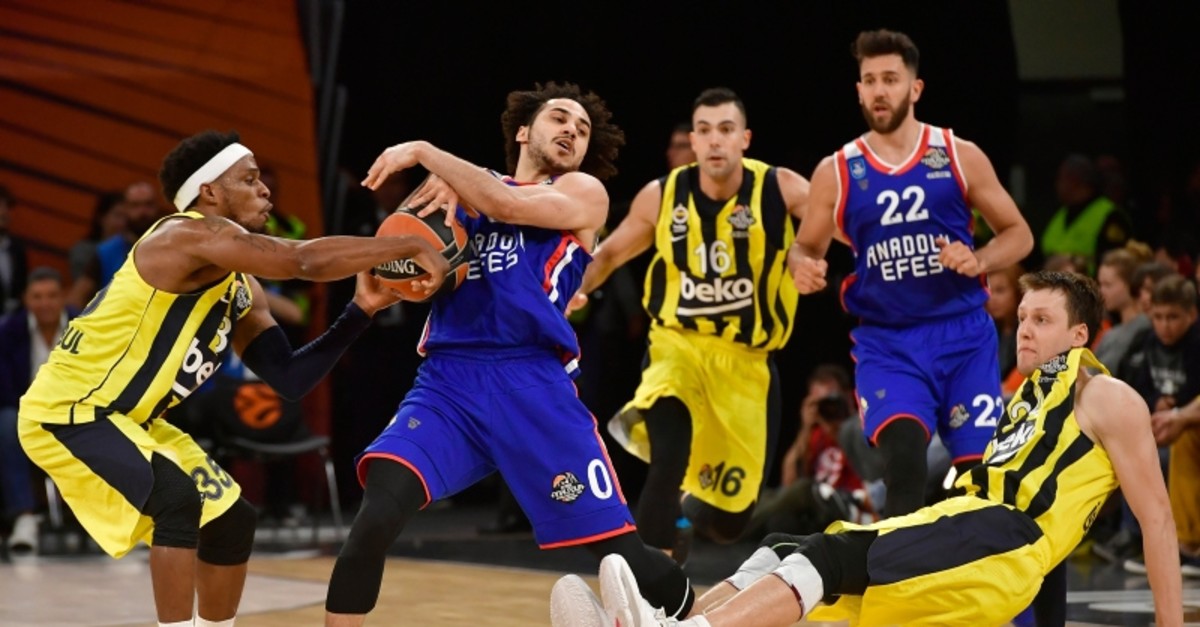 Fenerbahce's Ali Muhammed, left, and Anadolu's Shane Larkin, second left, challenge for the ball as Fenerbahce's Jan Vesely, right falls to the ground during the Euroleague Final Four semifinal basketball match (AP Photo)