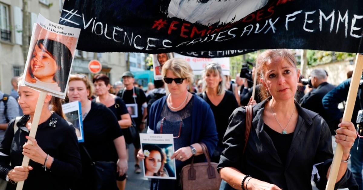 Women hold pictures of victims and placards denouncing the violence against women as they take part in a protest march (AFP Photo)