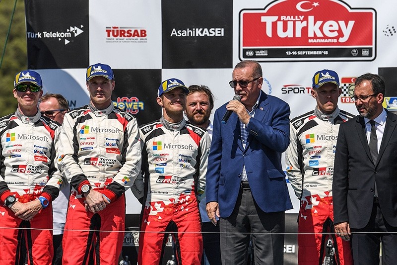 President Recep Tayyip Erdou011fan (3thR) gives a speech next to Estonian driver Ott Tanak (2ndR) and his co-driver Martin Jarveoja (3rdL) after they won the 2018 World Rally Championship, at Marmaris district in Muu011fla, on Sept. 16, 2018. (AFP Photo)