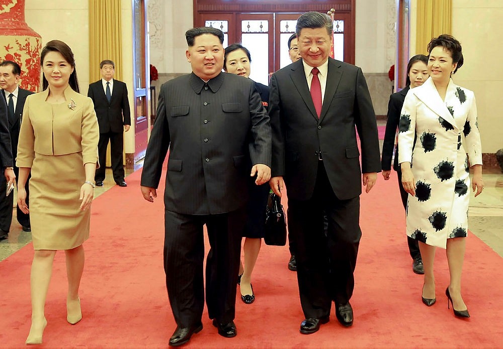 This picture from North Korea's official Korean Central News Agency (KCNA) taken on March 26, 2018 and released on March 28, 2018 shows China's President Xi Jinping (2nd R), his wife Peng Liyuan (R), North Korean leader Kim Jong Un (2nd L) and his wife Ri Sol Ju (L) walking in the Great Hall of the People in Beijing.