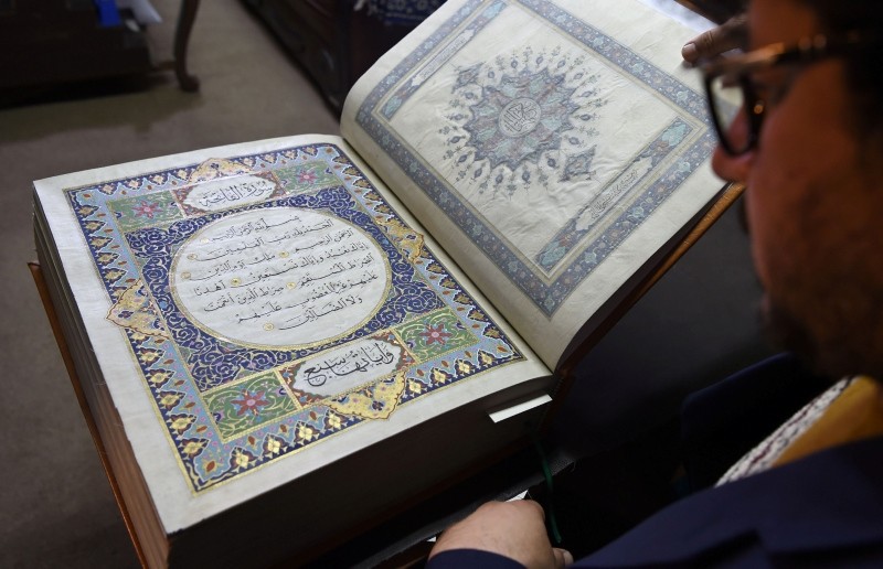 In this photograph taken on April 19, 2018 Afghan master miniature artist Mohammad Tamim Sahibzada shows a handmade Quran made with silk fabric at the Turquoise Mountain Foundation in Mourad Khani, in the old city section of Kabul. (AFP Photo)