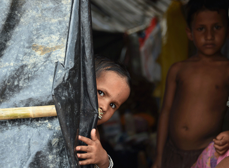 Rohingya refugee children look our from their makeshift shelter at the refugee camp of Balukhali near the locality of Ukhia (AFP File Photo)