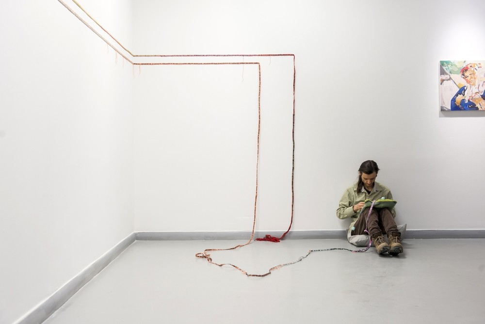 Artist Eu015fref Yu0131ldu0131ru0131m seen weaving in the exhibition area. u200b