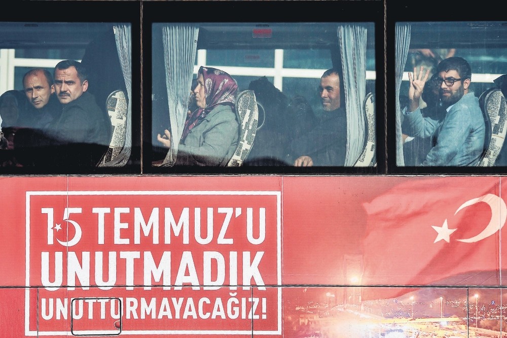 Relatives of victims who were killed on the Bosporus Bridge gesture as they arrive by bus with a sign reading: u201cWe did not forget July 15, we will not let it be forgottenu201d