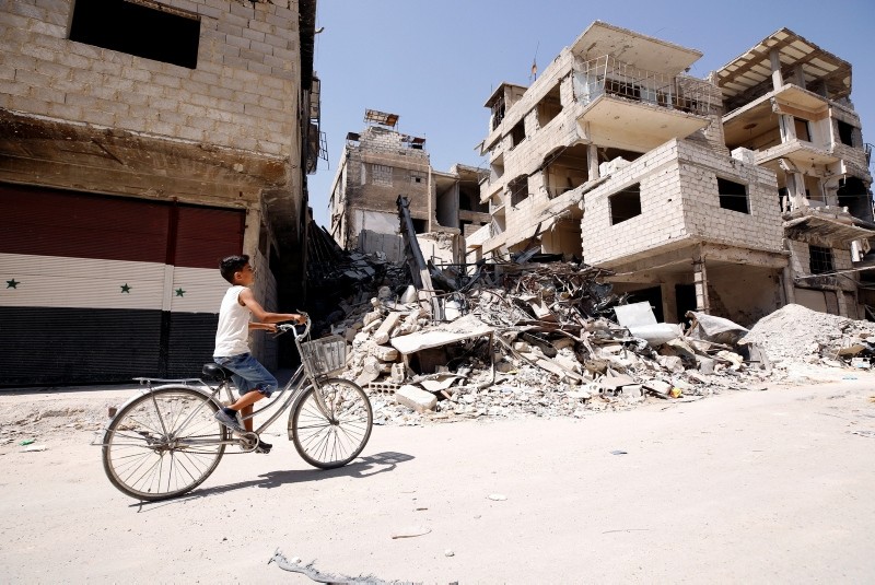 A boy rides on a bicycle along a damaged street in the town of Kafr Batna, in eastern Ghouta, Syria, Sept. 5, 2018. (Reuters Photo)