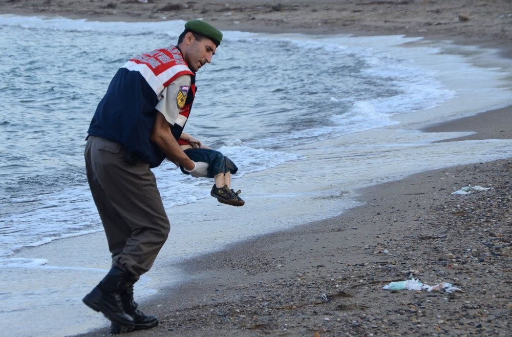 A Turkish police officer carrying the dead body of Aylan Kurdi, a three-year-old migrant child, off the shores of Bodrum in southern Turkey, after a boat carrying refugees sank while attempting to reach the Greek island of Kos, Sept. 2, 2015.