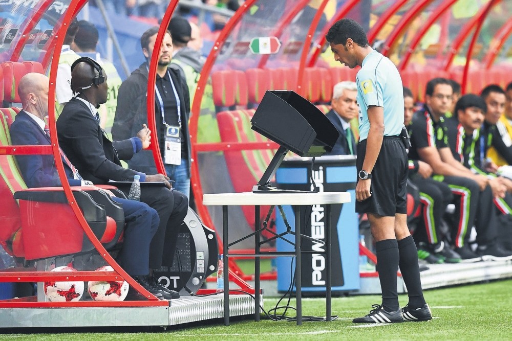 The assistant referee check the video playback during the 2017 Confederations Cup group A football match between Mexico and Russia at the Kazan Arena Stadium.