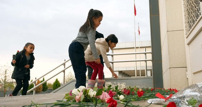 فتيات يضعن الزهور أمام المدرسة التي استهدفها تنظيم بي كي كي بالصواريخ وقتلت إحدى مدرساتها DHA