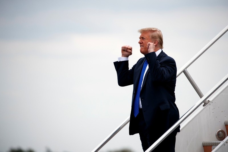 President Donald Trump pumps his fist towards supporters as he steps off Air Force One after arriving at Philadelphia International Airport, Tuesday, Oct. 2, 2018, in Philadelphia. (AP Photo)