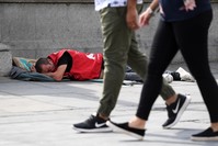 A homeless man sleeps on the pavement in central London, U.K.