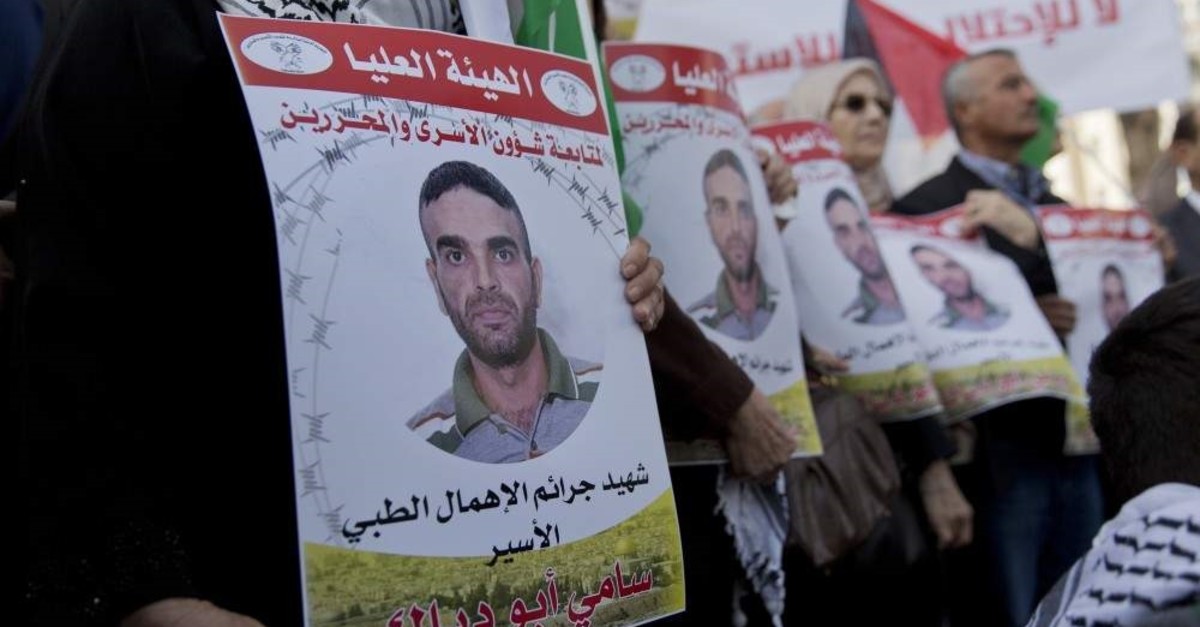 Protesters fly Palestinian flags and carry posters with pictures of Palestinian prisoner Sami Abu Diak, who is in an Israeli jail, Ramallah, Nov. 26. 2019. (AP Photo)