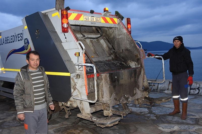 Feridun u00d6zsoy (L), village headman of Muu011fla's Akyaka neighborhood, works an evening shift as garbage truck driver. (DHA Photo)