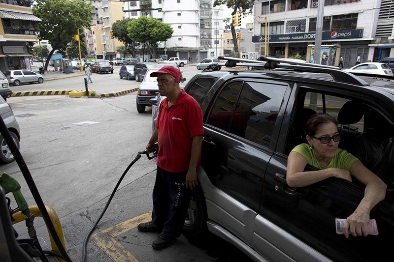 In this March 23, 2017 file photo, an employee pumps gas for a customer at a gas station in Caracas, Venezuela. (AP Photo)