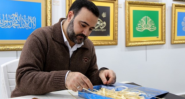 إمام مسجد في تركيا وهو يخط لوحات فنية من أعواد القمح