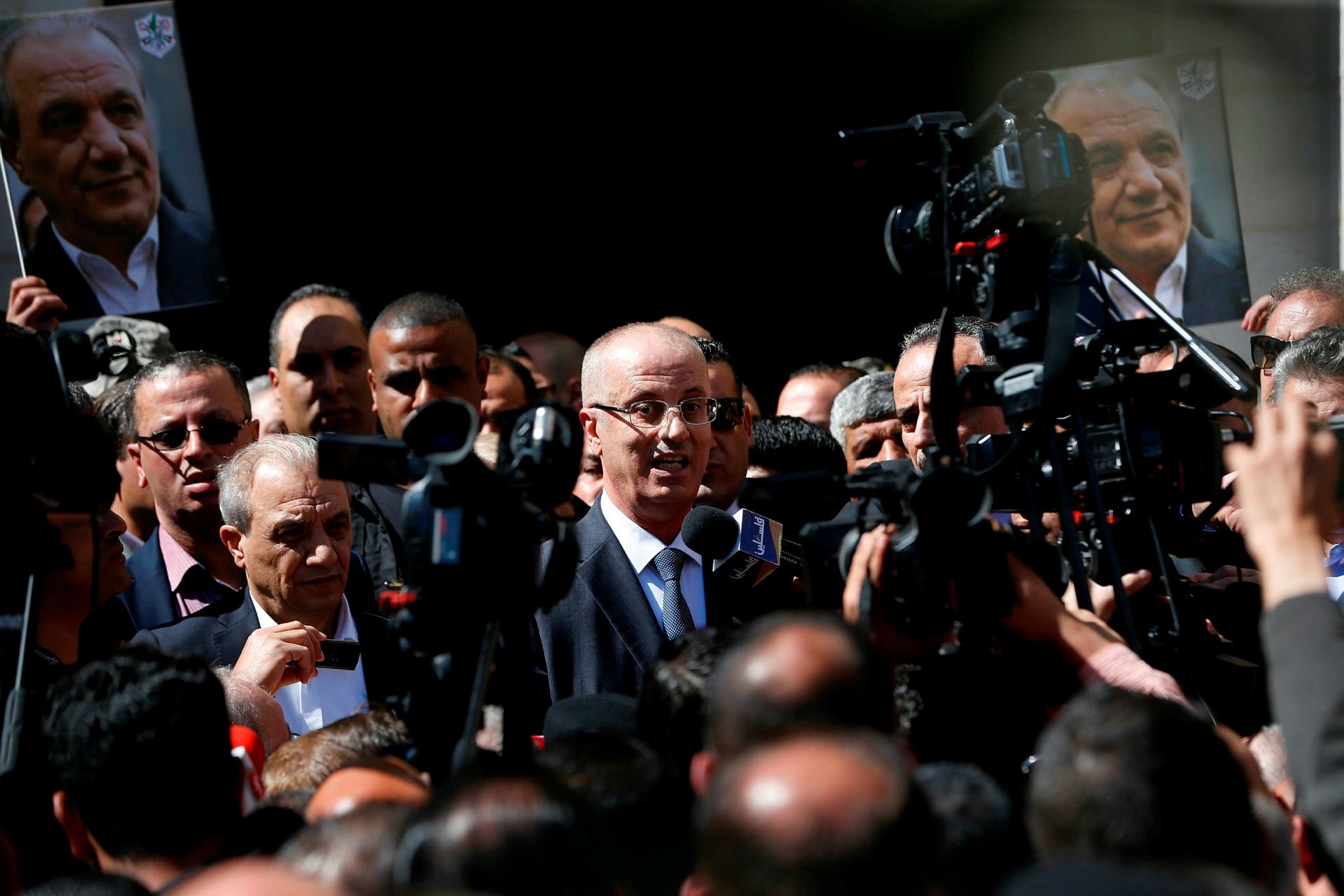 Palestinian Prime Minister Rami Hamdallah (C) addresses the media upon his arrival in the West Bank town of Ramallah following his return from the Gaza Strip where an explosion targeted his convoy, March 13.
