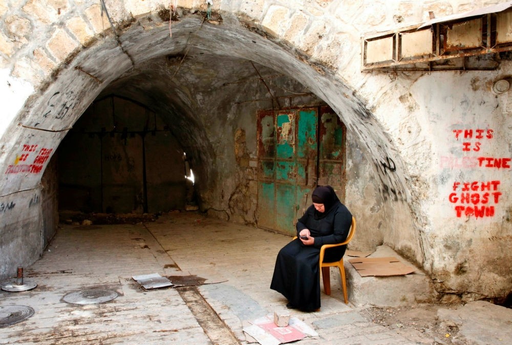 A Palestinian woman sits in the old city of the West Bank city of Hebron on May 8.