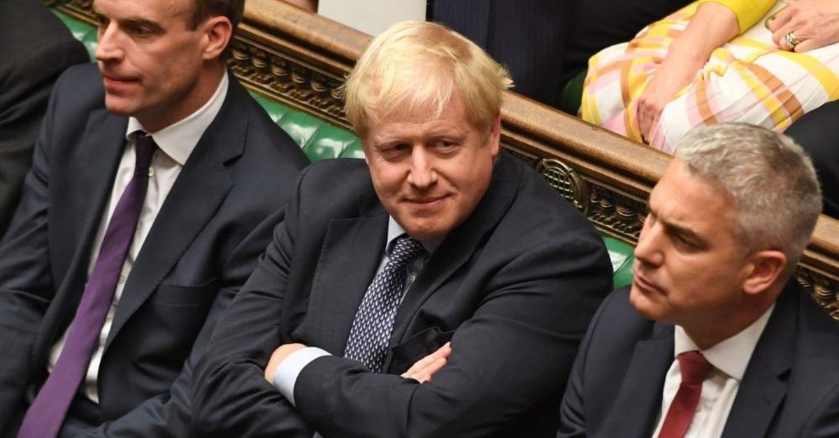 Britain's Prime Minister Boris Johnson (C) smiles in the House of Commons, London, Oct. 19, 2019. (AFP Photo)