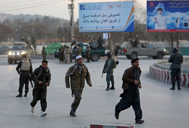 People run away from the site of a clash between insurgents and security forces in Kabul, Afghanistan, Monday, Dec. 24, 2018 (AP Photo)
