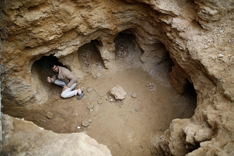 Abdel-Karim Cafran, a Palestinian resident of Beit Hanun, collects pottery fragments at a freshly-discovered cemetery in the garden of his house in the town in the northern Gaza Strip (AFP Photo)