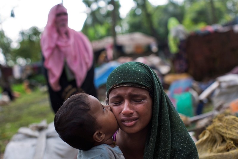 A Rohingya Muslim child places a kiss on his mother's cheek as they rest after having crossed over from Myanmar to the Bangladesh side of the border near Cox's Bazar's Teknaf area. (AP Photo)