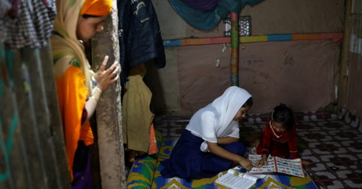 Yasmin, a girl who was expelled from Leda High School for being a Rohingya, helps her younger sister to study in Leda camp in Teknaf, Bangladesh, March 5, 2019. (Reuters Photo)