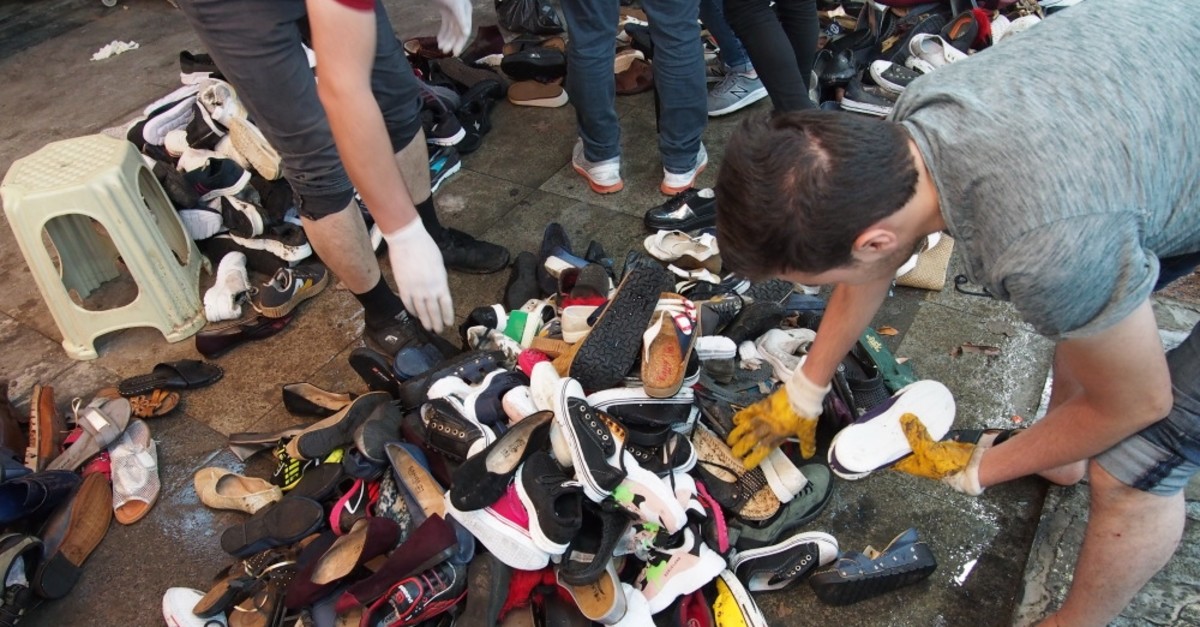 Shopkeepers sort out shoes salvaged from the floods at an underpass lined with shops in Eminu00f6nu00fc, Aug. 21, 2019.