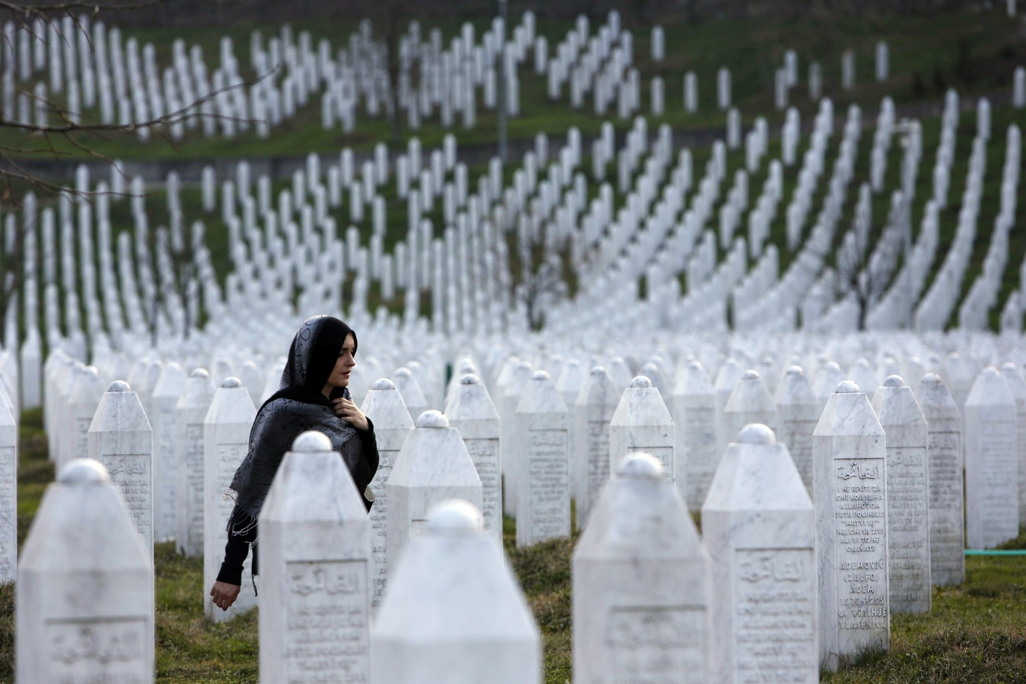 Bosnian woman walks among gravestones at Memorial Centre Potocari near Srebrenica, Bosnia and Herzegovina. (AP Photo)