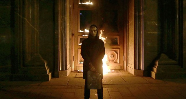 الفنان الروسي بيوتر بافلنسكي أمام بوابة مصرف فرنسا المشتعلة