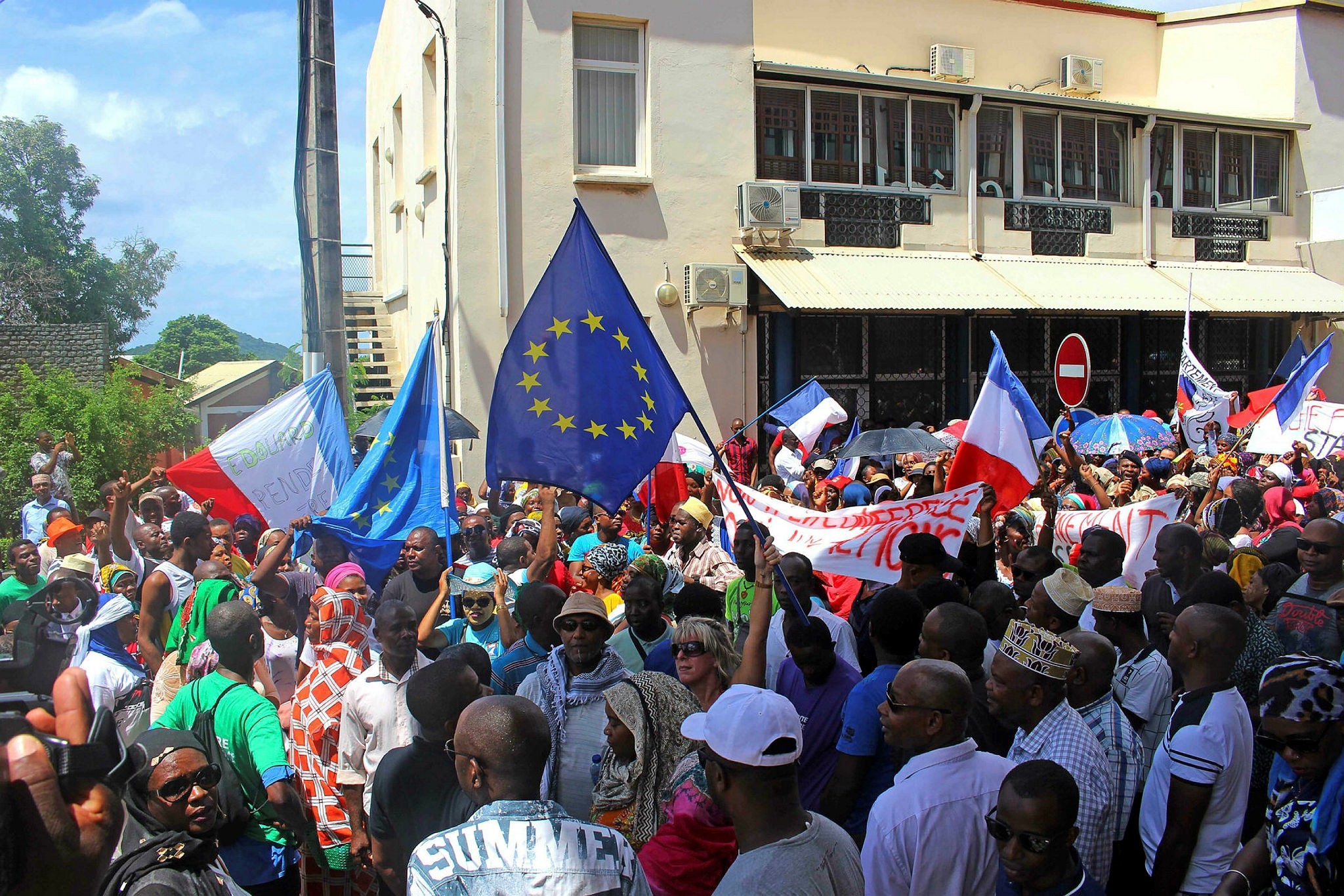 Protesters wave French and European Union flags outside the Mayotte Departmental Council in Mamoutzou, on the French Indian Ocean island of Mayotte, March 13.
