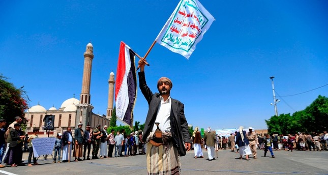يمني من أنصار جماعة الحوثي يحمل لافتة منددة بإسرائيل الفرنسية