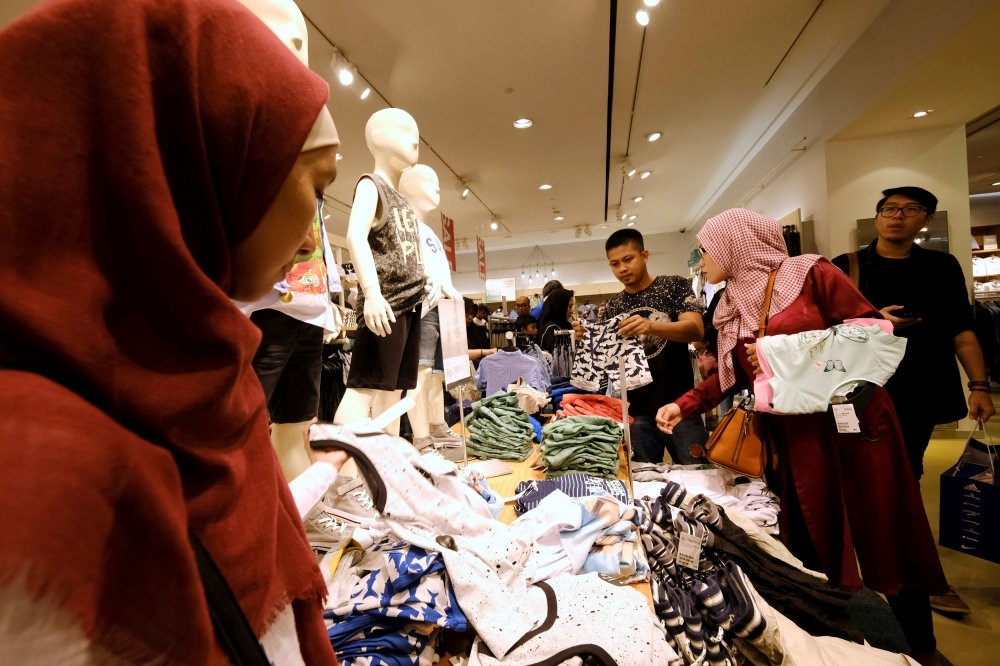 Customers hold clothes during late night Ramadan shopping at Gandaria Mall in Jakarta, Indonesia.