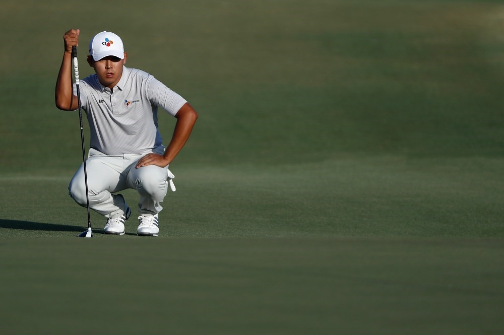 Si Woo Kim of South Korea lines up a shot during the final round of The Players Championship at the Stadium course at TPC Sawgrass.