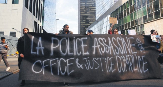 Members of several associations for the defense of asylum seekers' rights attend a protest in front of the immigration office in Brussels after a three-year-old girl died during a chase with police, May 18.