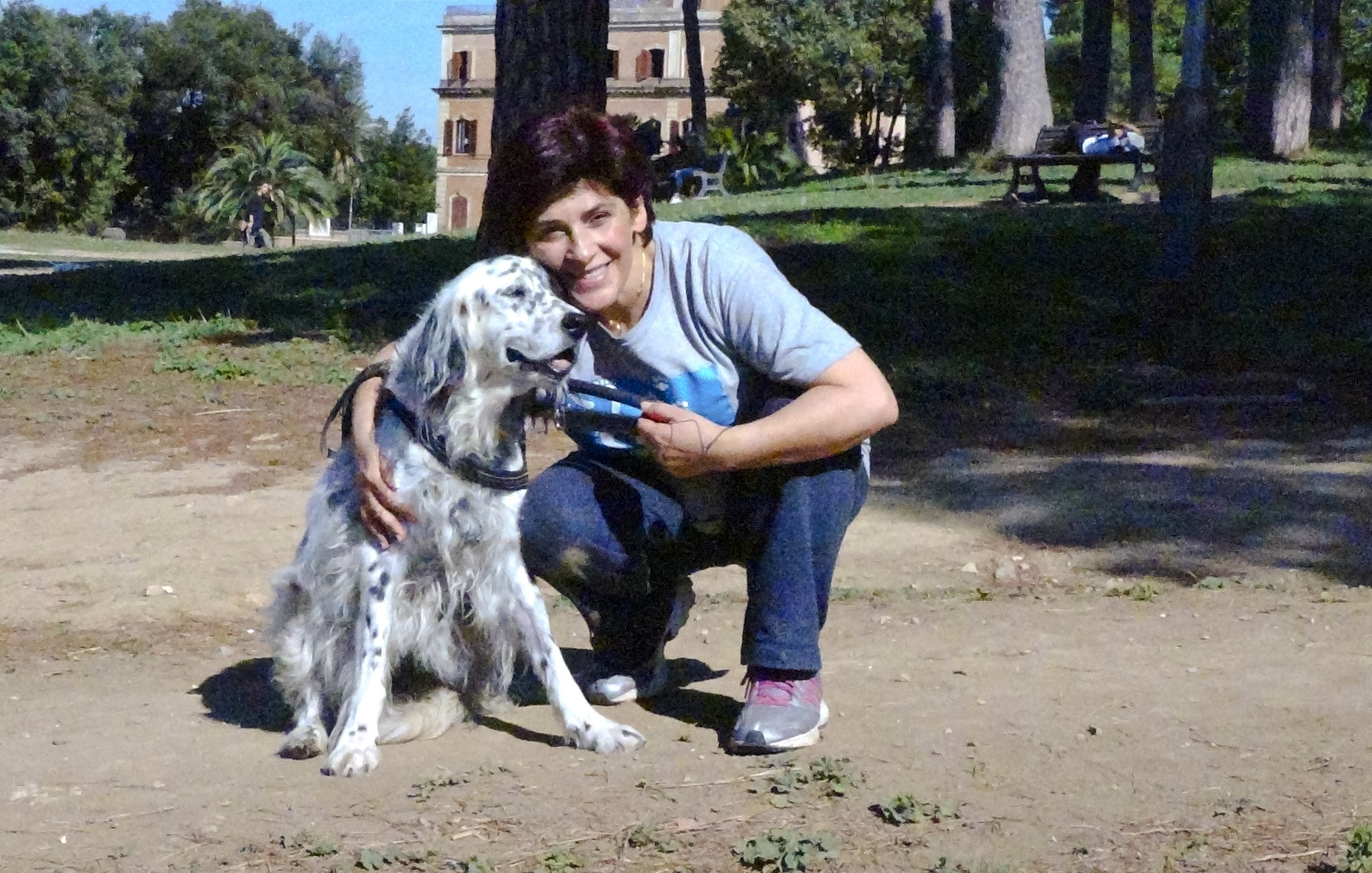 This undated photo made available Oct. 12, 2017, shows an Italian librarian who has won the right from her employer to use family sick leave to care for her ailing pet, posing with her dog Cucciola in a park in Rome. (AP Photo)