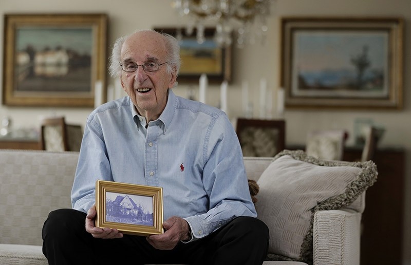 In this Friday, June 16, 2017 photo, Peter Hirschmann holds a photograph of his childhood home while posing for The Associated Press in his home in Maplewood, N.J. (AP Photo)