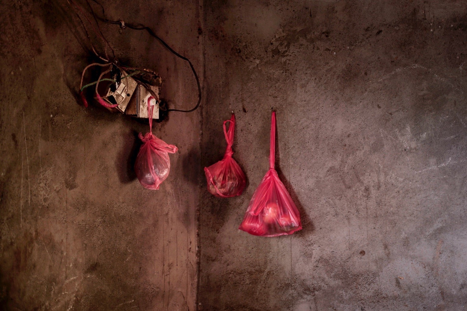 Food hangs in sacks on the wall of the home of a displaced family, in Lahj, southern Yemen. Many markets in Yemen have food but increasing numbers of people are unable to afford it in the economic collapse caused by the war.