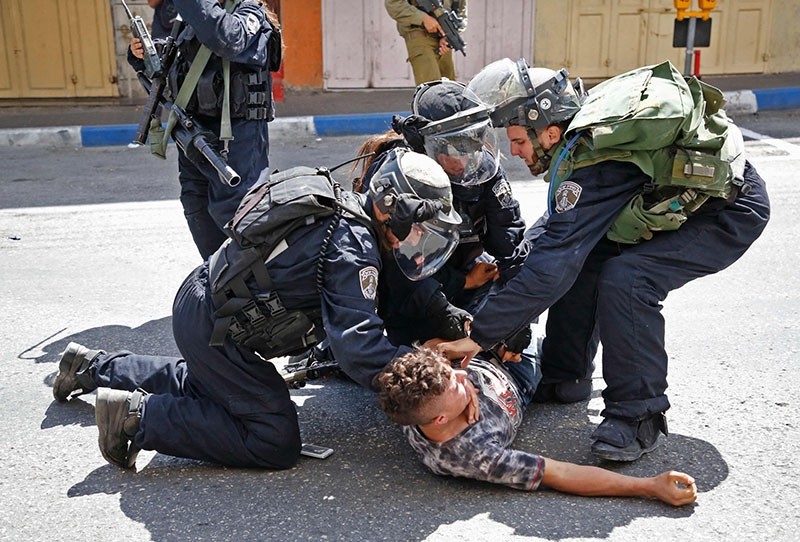 Israeli forces arrest a Palestinian youth in the city of Hebron in the Israeli-occupied West Bank, on July 28, 2017, as protests erupt after Israeli police barred men under 50 from Friday prayers in the Al-Aqsa Mosque. (AFP Photo)