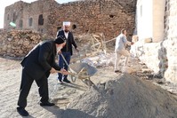 Rev. Savcu0131 shovels sand into a cart carried by imam Kardau015f.