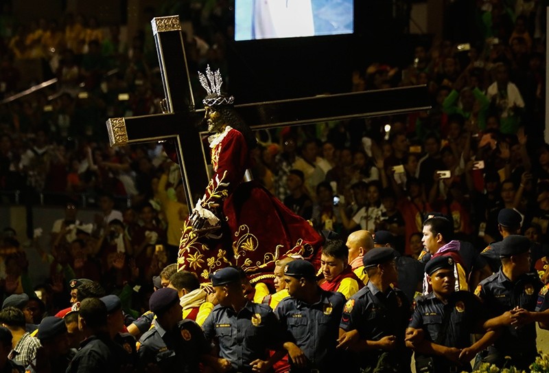 The Black Nazarene statue is taken from a stage to begin a procession as Catholic devotees flock around to mark its feast day in Manila, Philippines, Jan. 9, 2018. (EPA Photo)