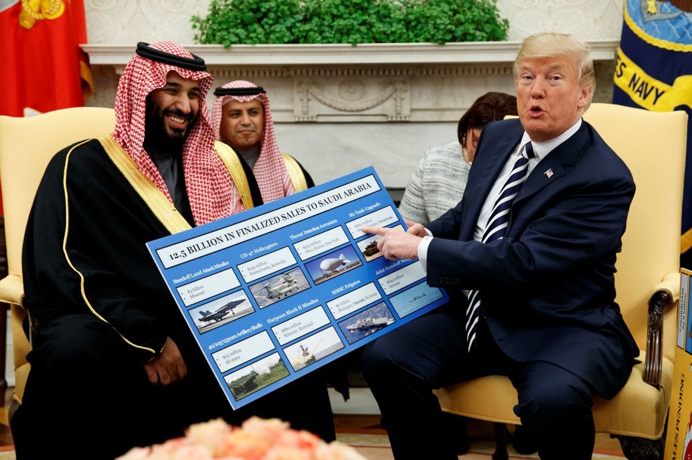 President Donald Trump shows a chart highlighting arms sales to Saudi Arabia during a meeting with Saudi Crown Prince Mohammed bin Salman in the Oval Office of the White House, March 20.