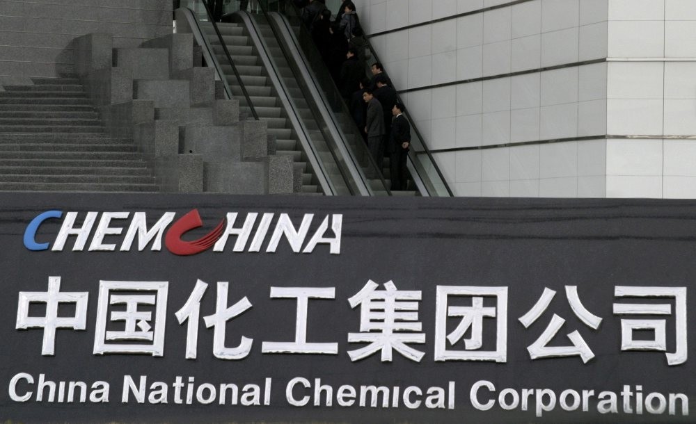People use an escalator outside the headquarters of ChemChina (China National Chemical Corporation) in Beijing.