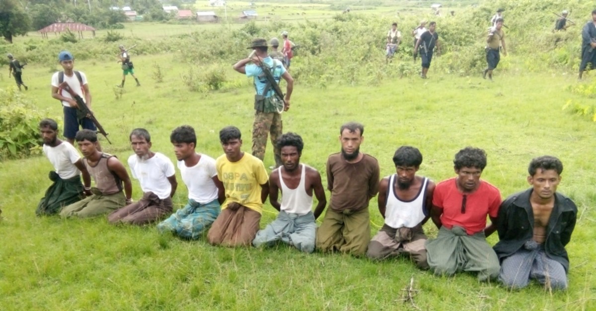 Ten Rohingya men with their hands bound kneel as members of the Myanmar security forces stand guard in Inn Din village of Rakhine State, Myanmar, September 2, 2017. (Reuters Photo)