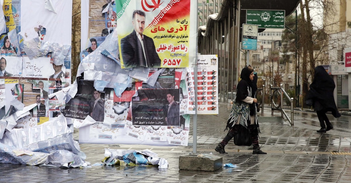 Iranians walk past electoral posters in capital Tehran (EPA Photo)