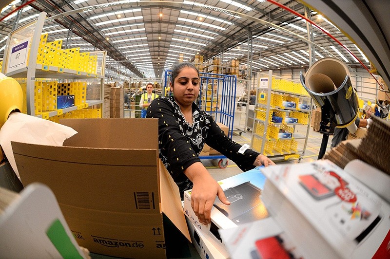 This file photo taken on Nov. 28, 2013, shows an employee packing orders at the Fulfillment Center for online retail giant Amazon in Peterborough, central England. (AFP Photo)