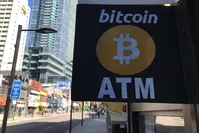A sign seen outside a business where a Bitcoin ATM is located in Toronto, Canada.