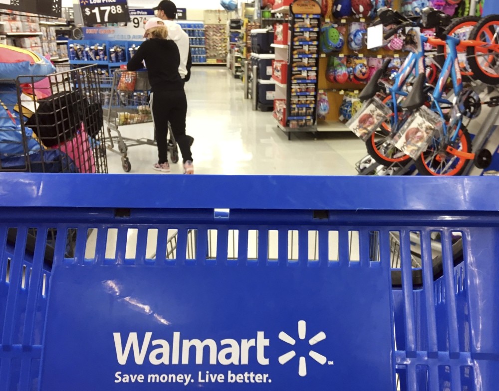Customers shop for food at Walmart in Salem, N.H. Walmart says it reviewed its firearm sales policy in light of the mass shooting at a high school in Parkland, Florida.