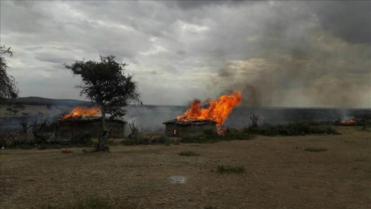 A plume of smoke billowing from a burned hut in Loliondo Tanzania.
