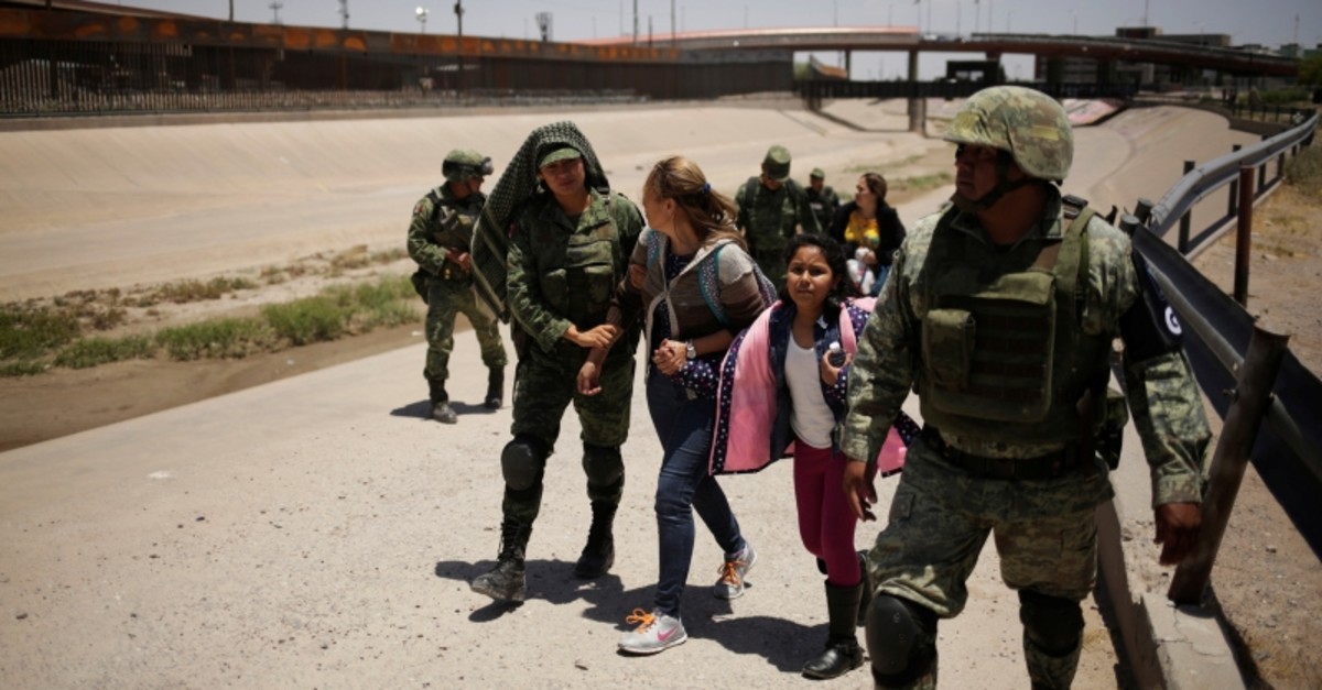 Members of Mexico's National Guard escort a woman and her daughter from Nicaragua after detaining them as they were trying to cross illegally the border between the U.S. and Mexico, in Ciudad Juarez, Mexico June 21, 2019. (REUTERS Photo)